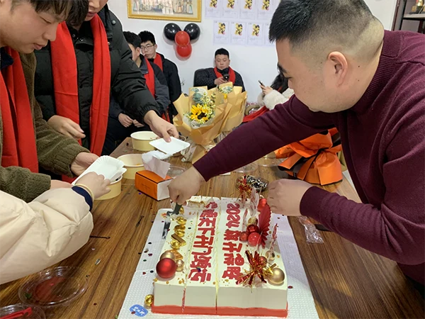 A person is cutting a cake and distributing it to everyone