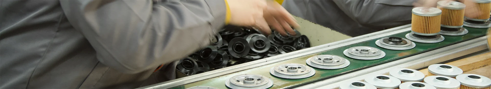 The worker is operating at the car fuel filter production line.