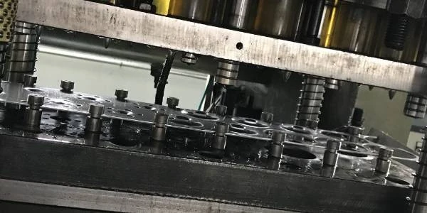 The stamping machine is producing cover plates and seal plates.