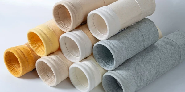 Various types of dust collector filter bags on a gray background