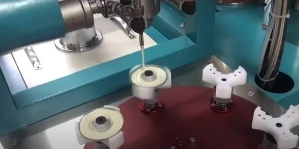 The gluing machine is applying adhesive to metal end cap.