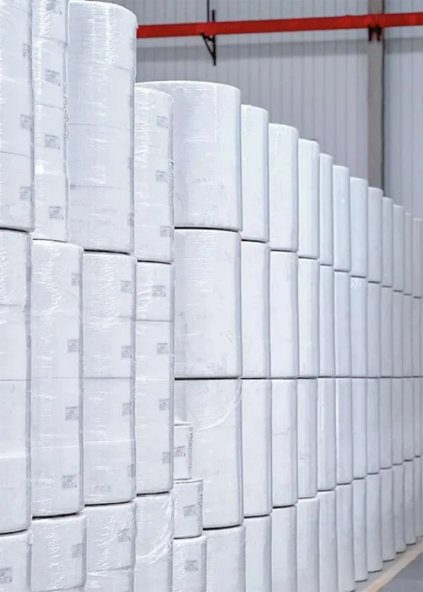 Neatly arranged rolls of non - woven fabric in the warehouse