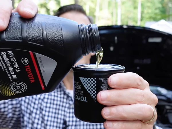 Pour oil into a Toyota car oil filter.